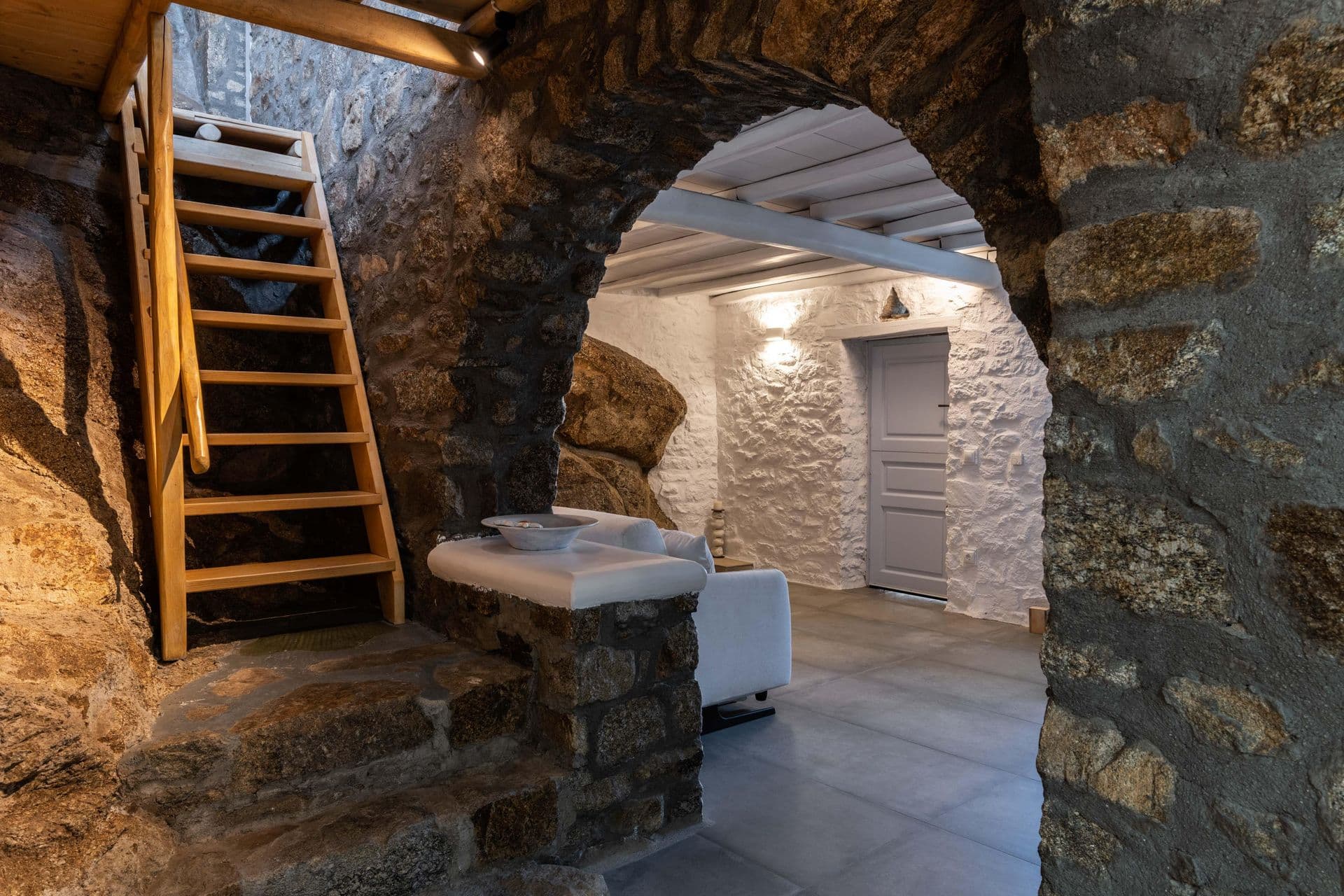 Carved stone archway and wooden staircase feature at Party Invitation villa