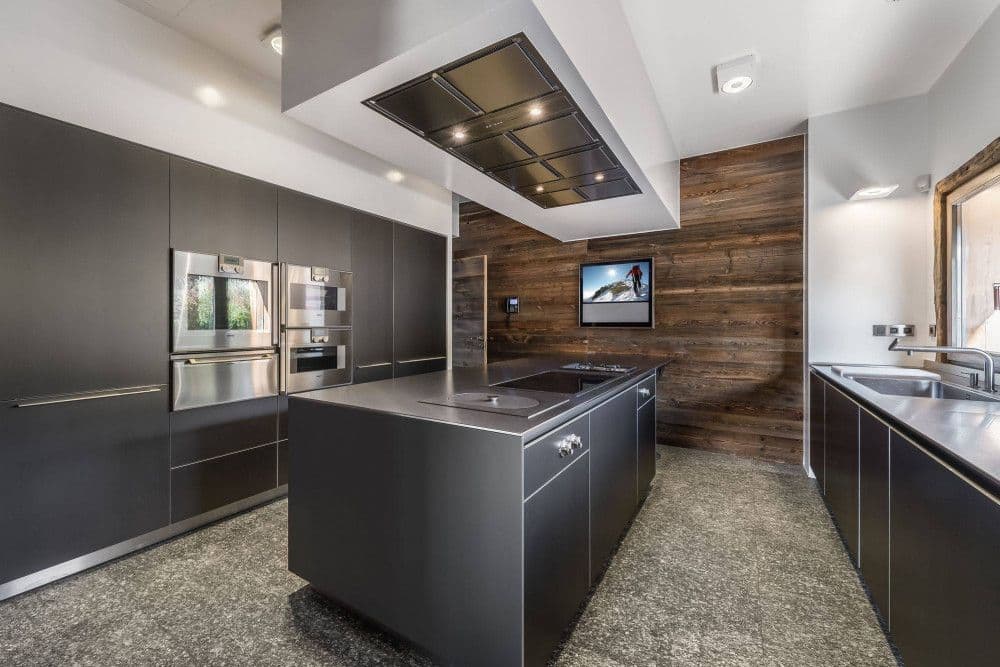 Dark contemporary kitchen with an island at Mont d'Arbois 4