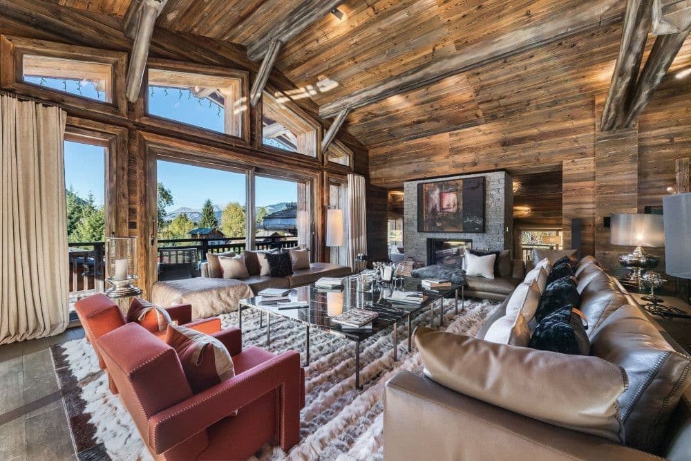 Living room with a fireplace opening to the terrace at Mont d'Arbois 4