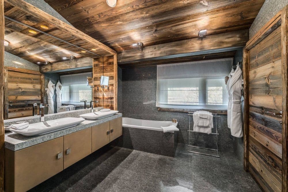 Master bathroom in stone and timber with a bath at Mont d'Arbois 4