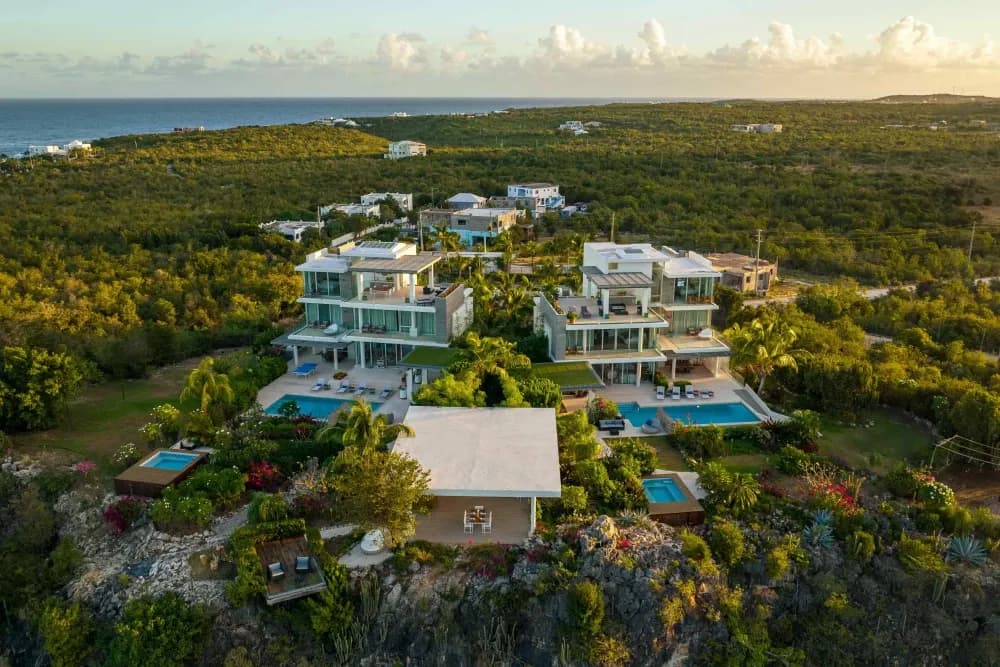 Aerial view of both Little Bay villas and their pools set above the Anguilla coast