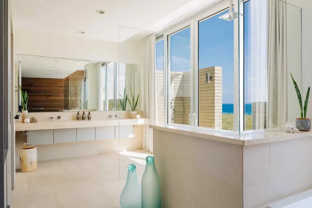 En-suite bathroom with a double vanity and sea-view walk-in shower at Little Bay Villas