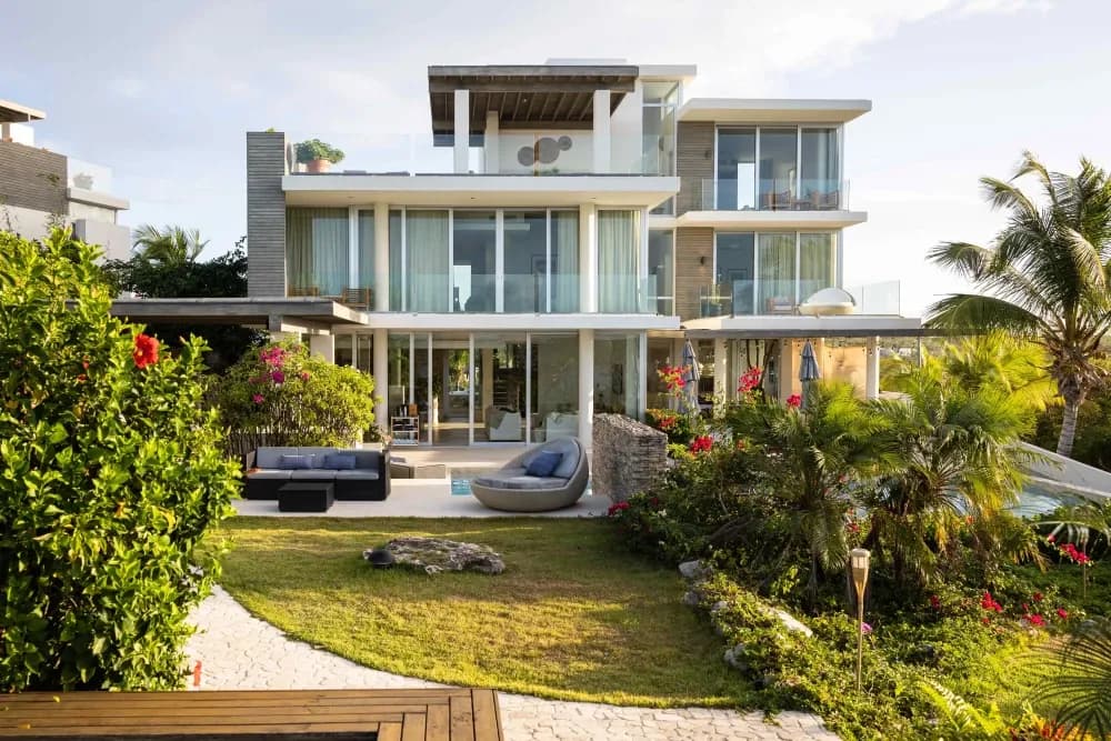 Contemporary villa seen across the lawn and tropical gardens at Little Bay Villas