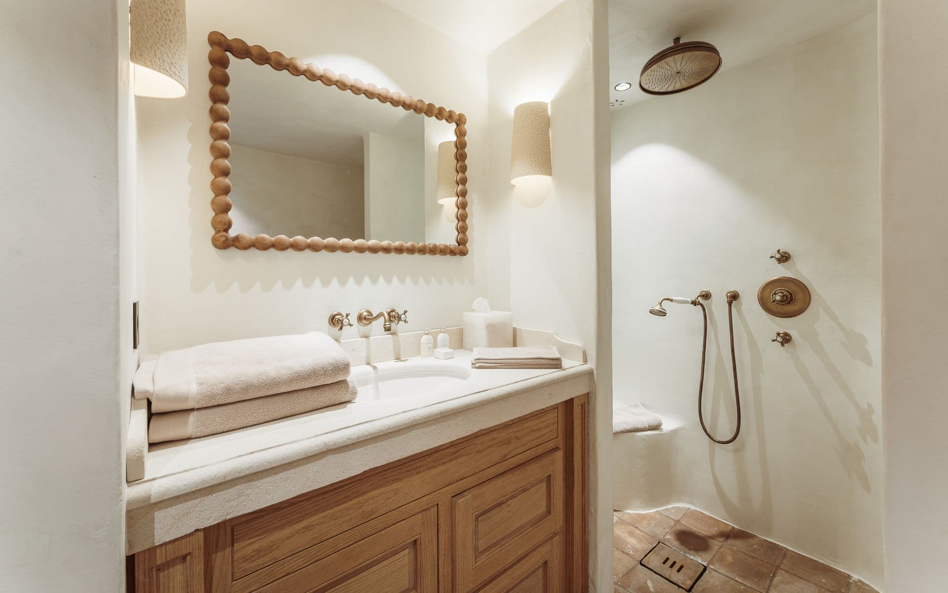 Bathroom with scalloped mirror, stone vanity and walk-in shower