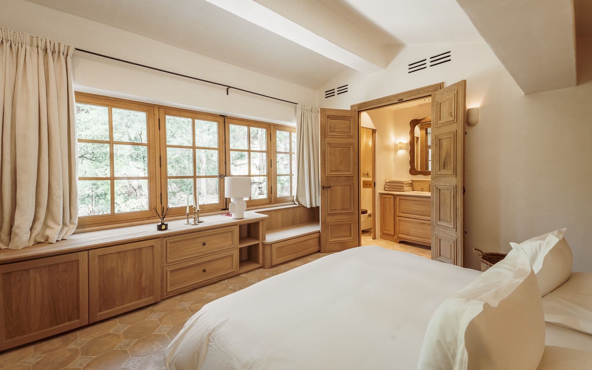 Bedroom with a long built-in window seat overlooking the garden