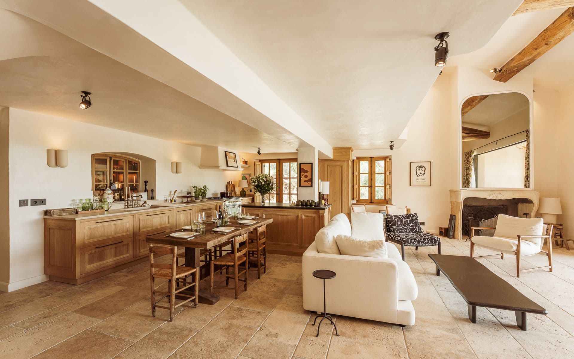 Open-plan living and kitchen area with wooden beams and stone floor