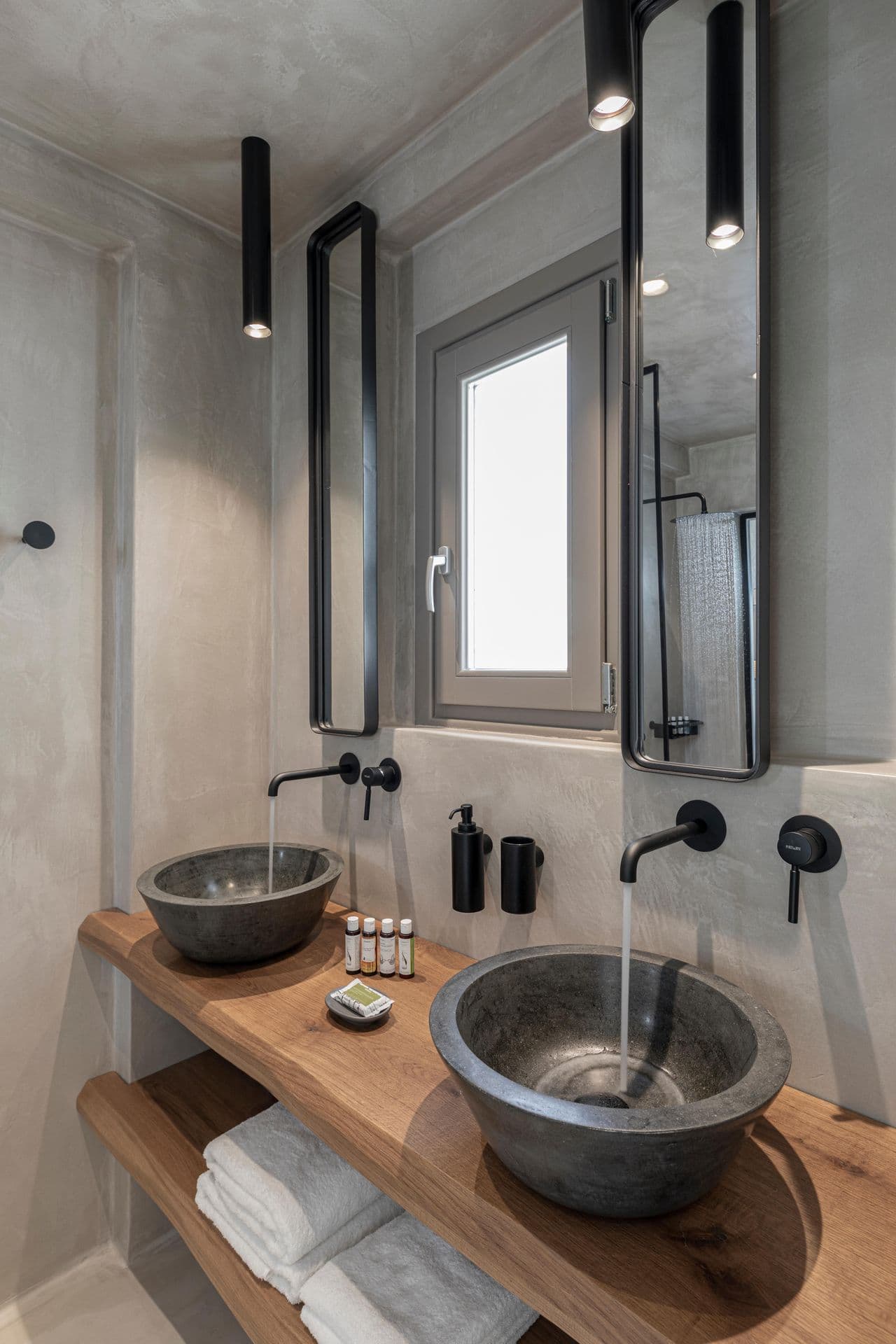 Bathroom with twin dark stone vessel sinks and wood counter at Smile Upon You