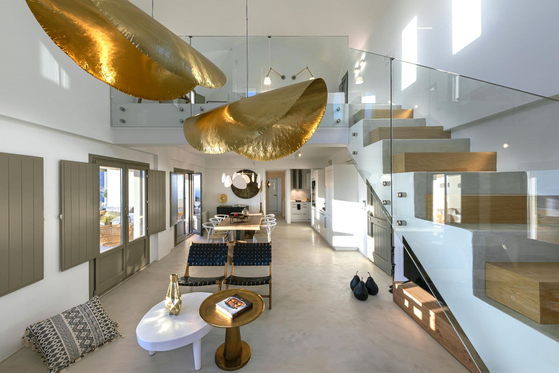 Living room at Smile Upon You with sculptural gold pendant lighting and open staircase