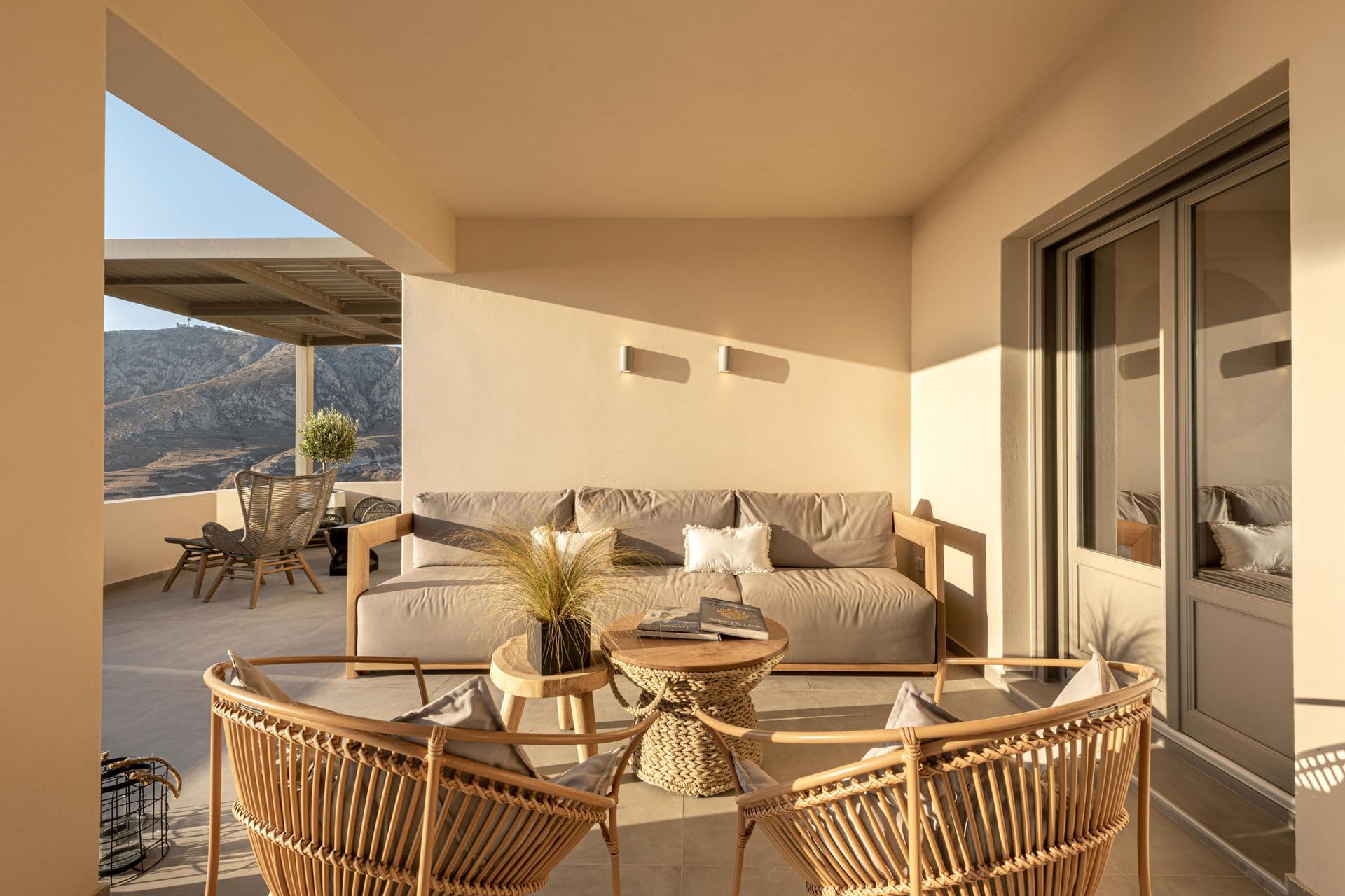Covered terrace lounge with rattan seating and hillside views at Smile Upon You