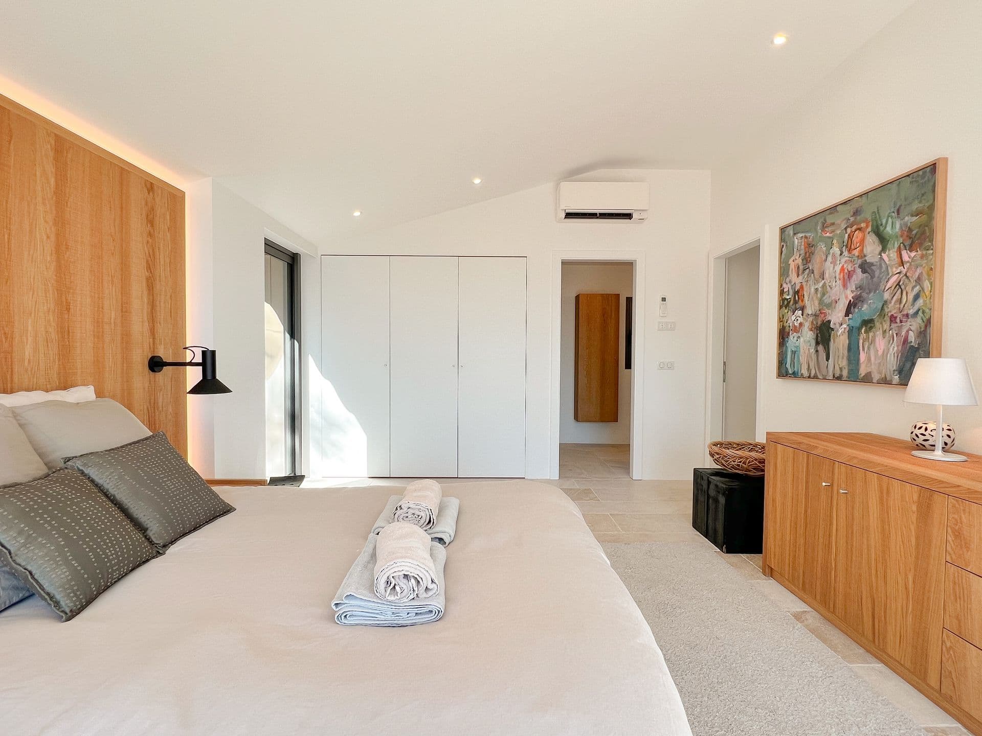 Oak double bedroom with a fitted wardrobe and artwork at Coastal Azure, Theoule-sur-Mer