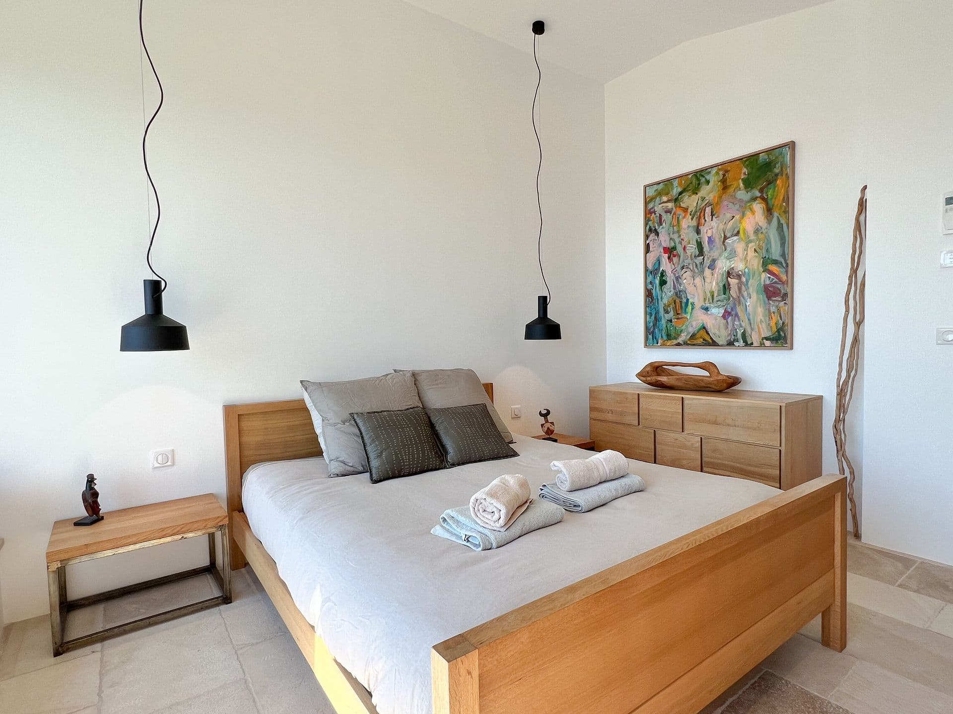 Double bedroom with an oak bed and abstract artwork at Coastal Azure, Theoule-sur-Mer