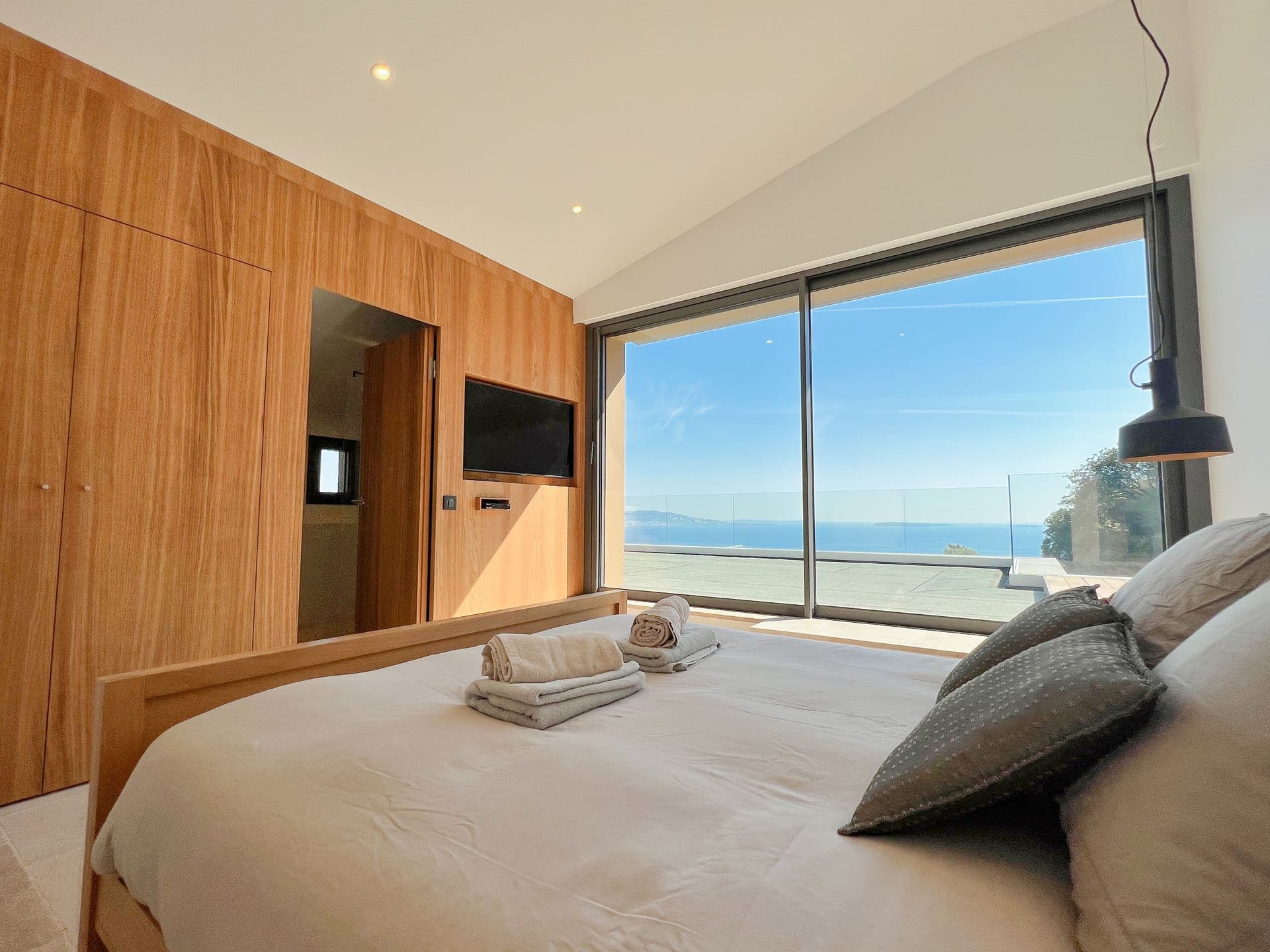 Oak double bedroom with sliding doors to a sea terrace at Coastal Azure, Theoule-sur-Mer