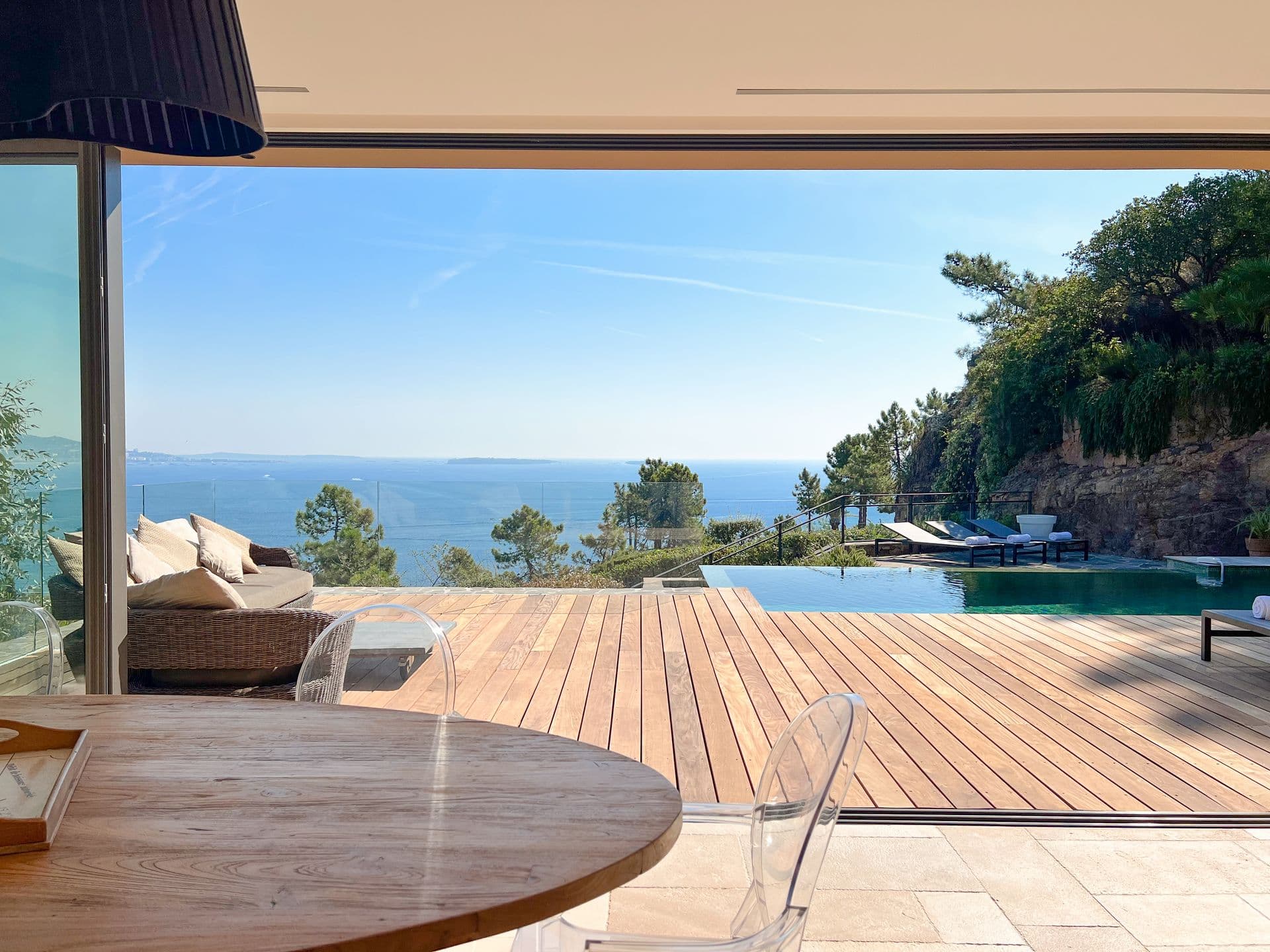 Breakfast table by folding glass doors onto the pool and sea at Coastal Azure, Theoule-sur-Mer