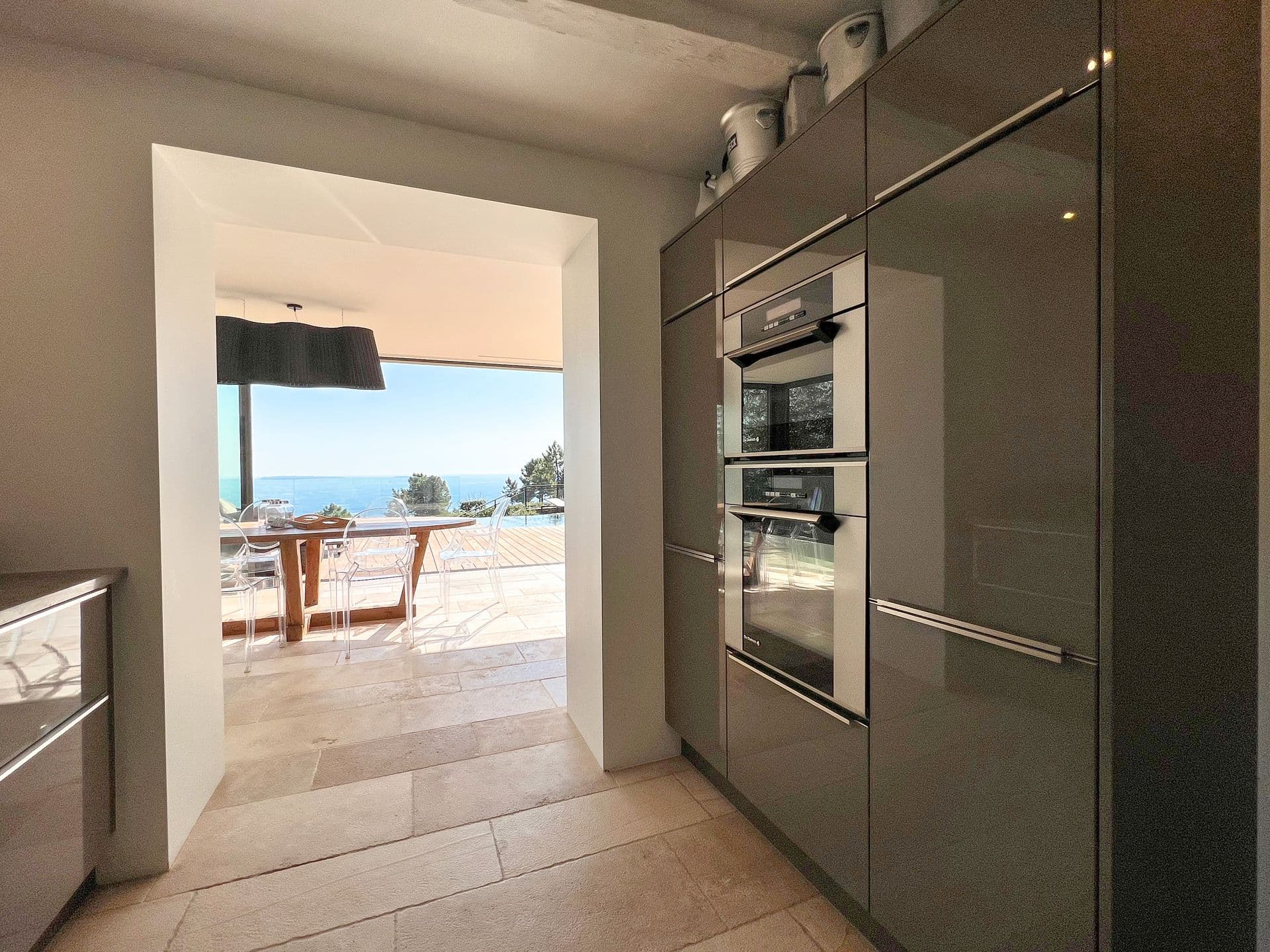 Steel and gloss kitchen with ovens and a sea-view window at Coastal Azure, Theoule-sur-Mer