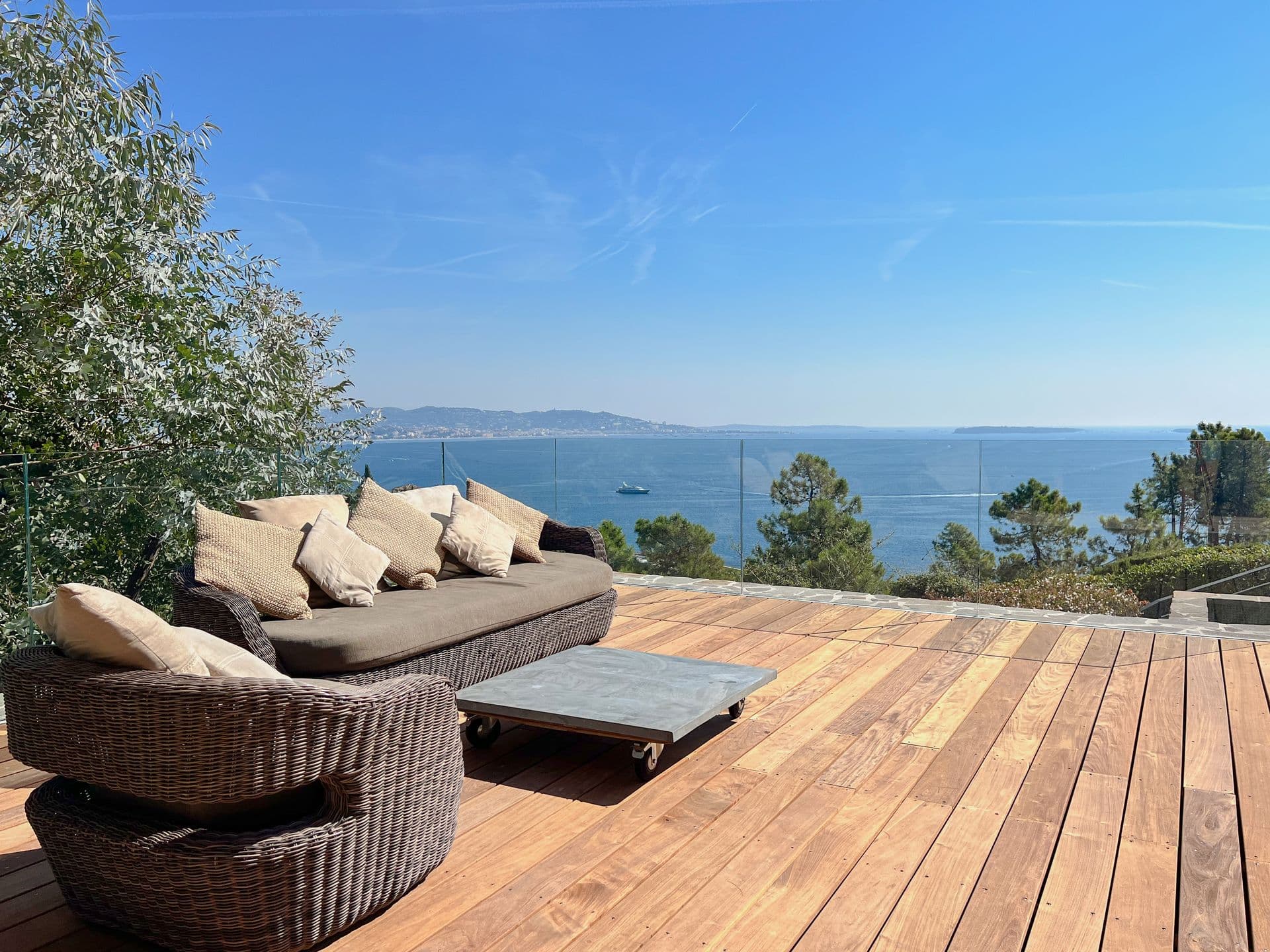Timber deck lounge with rattan seating and a sea view at Coastal Azure, Theoule-sur-Mer