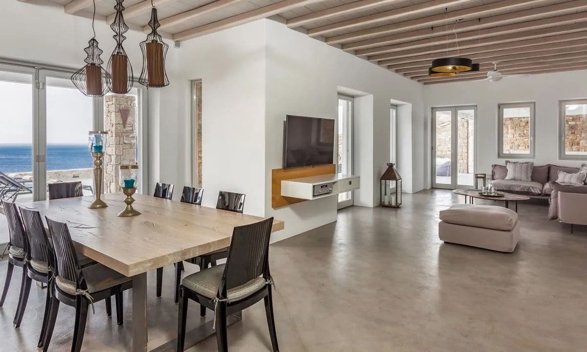 Indoor dining table for eight beside sea-view doors at Ancient Azure Vistas, Mykonos