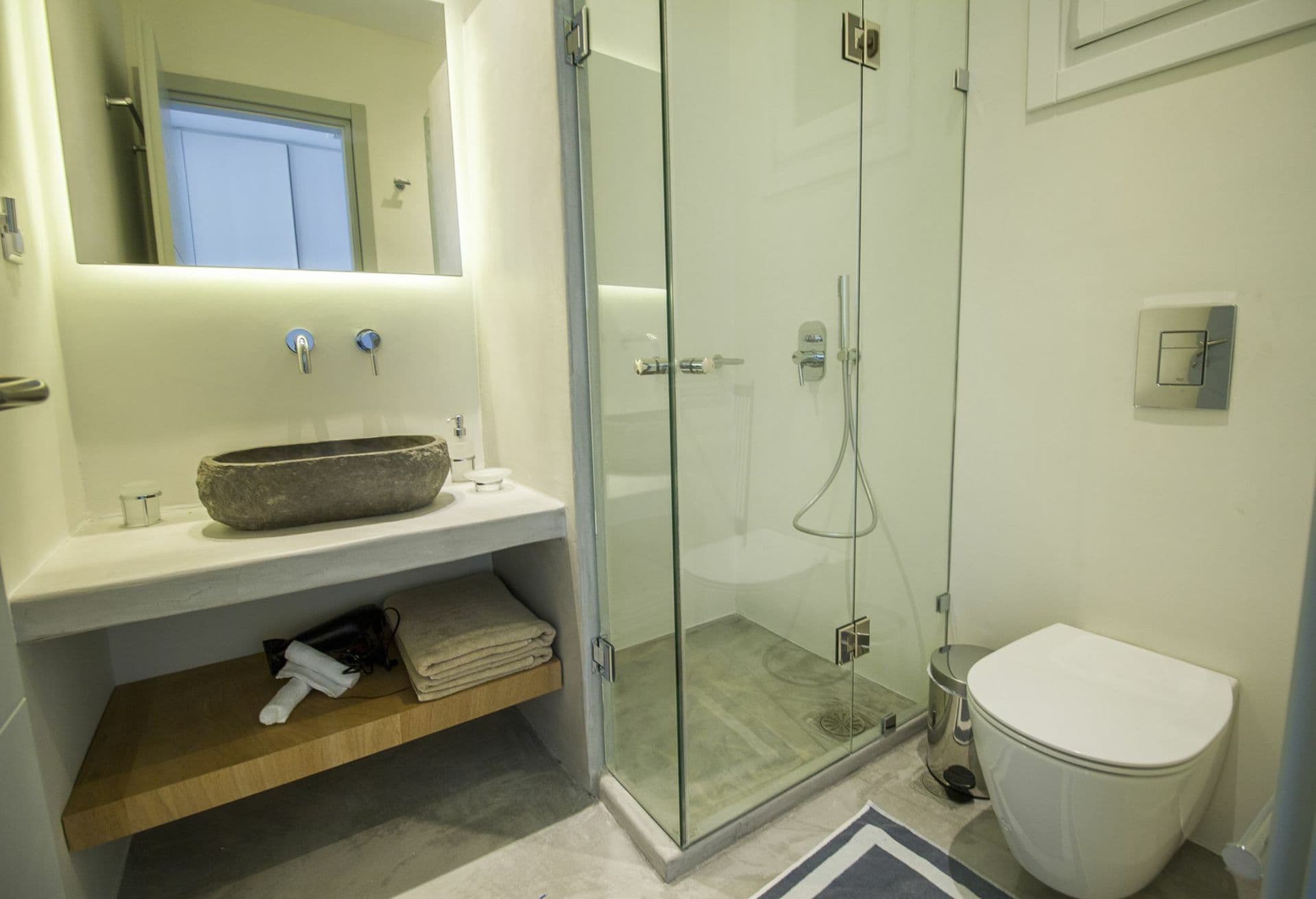 En-suite with a stone vessel basin and glazed walk-in shower at Ancient Azure Vistas, Mykonos
