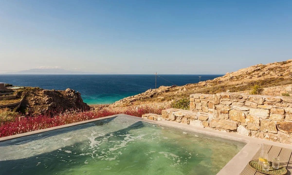 Pool on a dry-stone terrace above the sea and a sandy cove at Ancient Azure Vistas, Mykonos