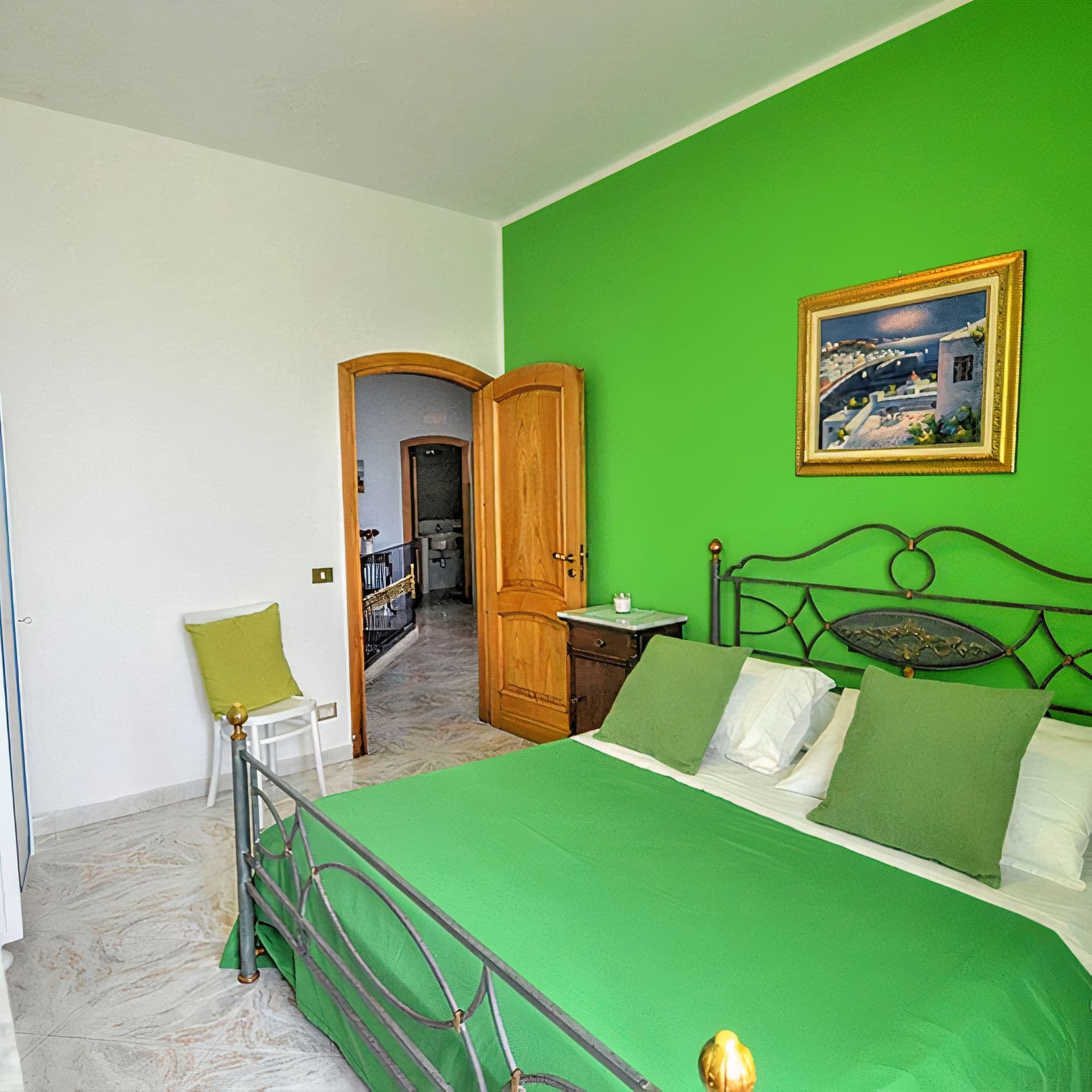A bedroom with a wrought iron bed set against a vivid green accent wall