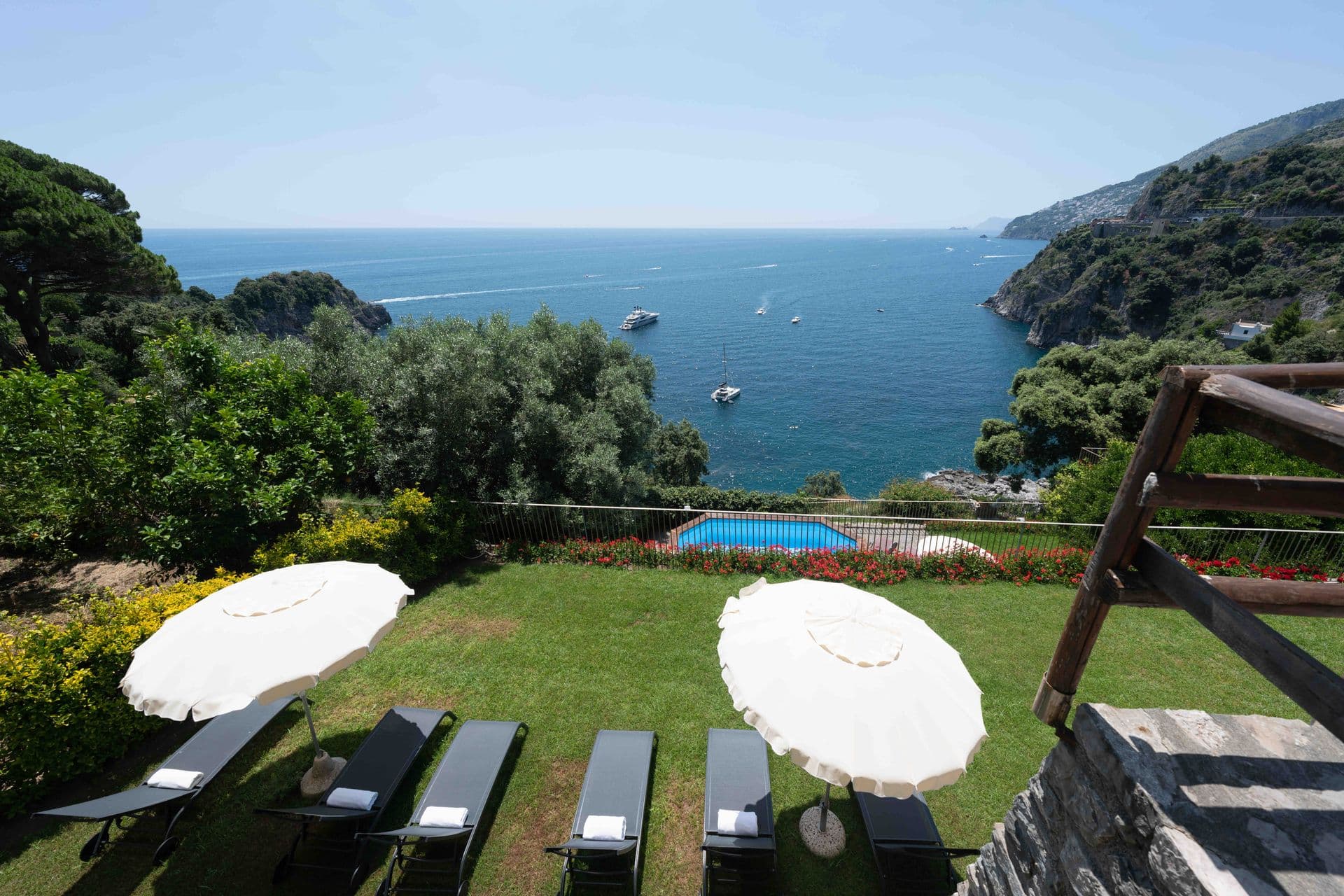 Sun loungers and parasols beside the pool with a sweeping sea view