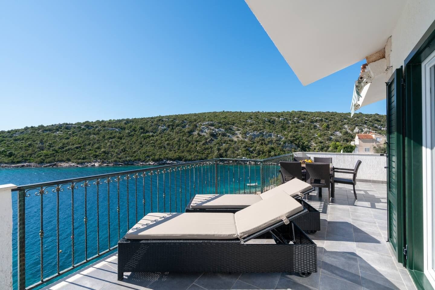 Living room with a grey sofa and balcony doors to the sea at Blue All Around, Marina, Croatia