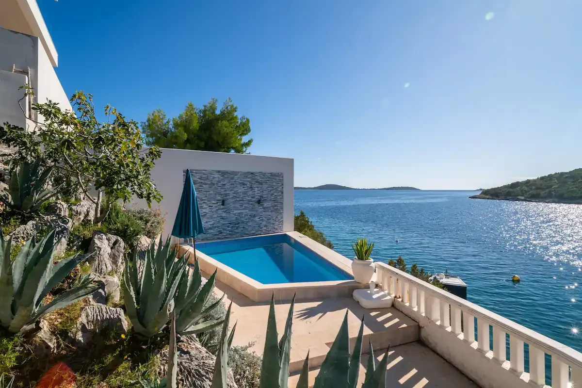 Balcony with loungers and a dining set above the bay at Blue All Around, Marina, Croatia