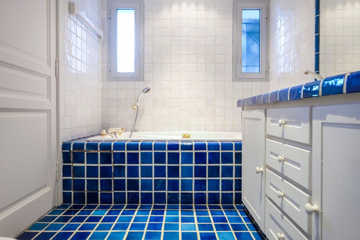 Bathroom with a sunken cobalt-blue tiled bathtub