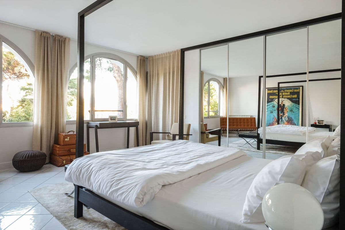 Bedroom with a black four-poster bed against a mirrored wall