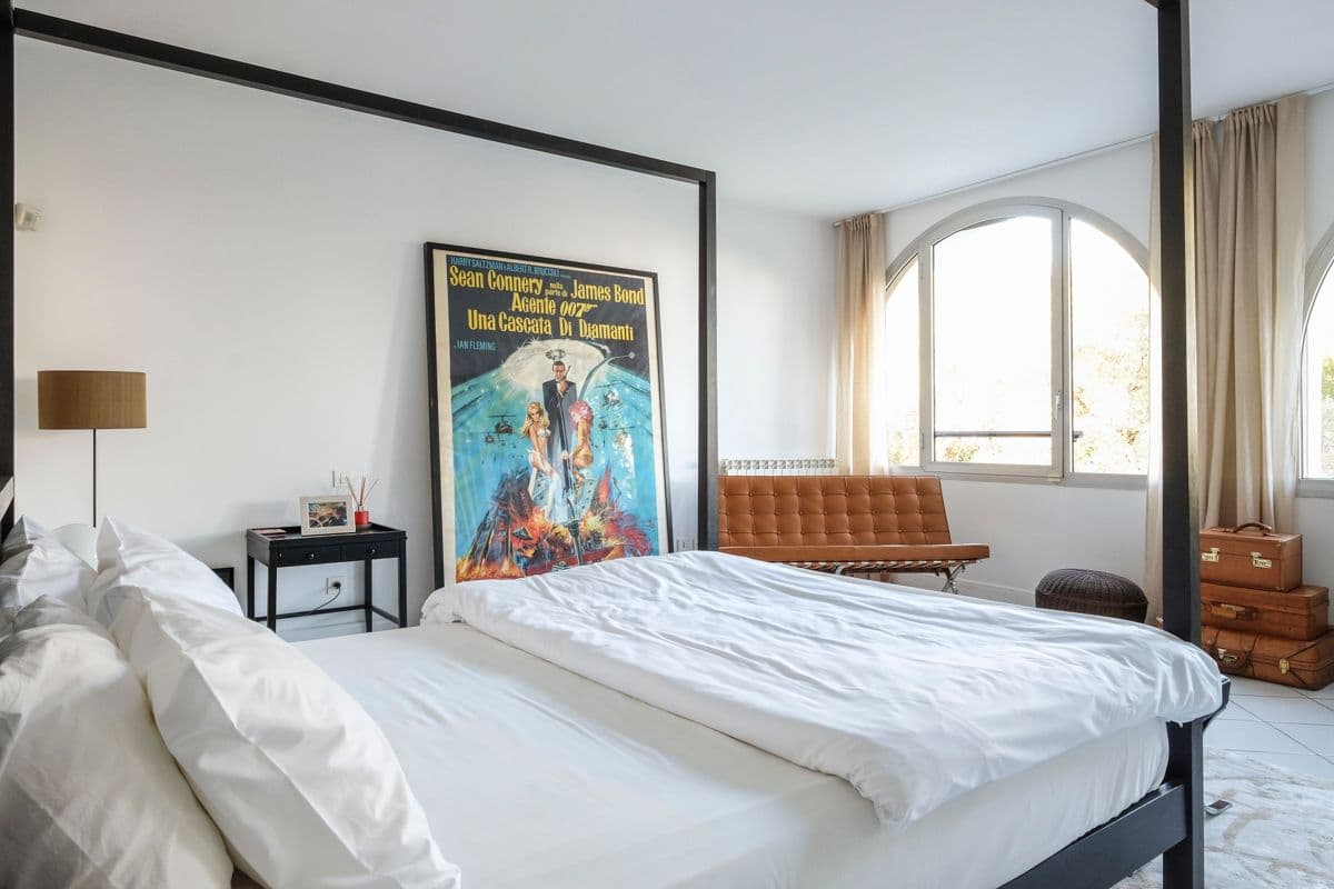 Bedroom with a four-poster bed and vintage framed poster