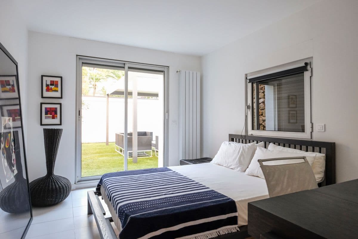 Bedroom with navy striped bedding and doors opening to the garden