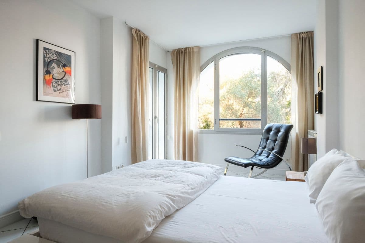 Bedroom with twin lamps, armchair and a vintage motoring poster