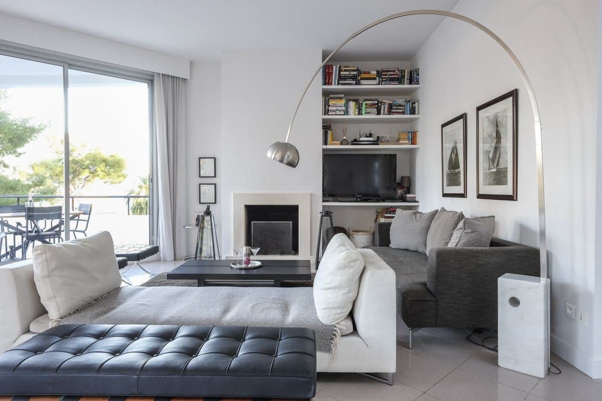 Living room with black leather chaise, grey sofas and an arc floor lamp