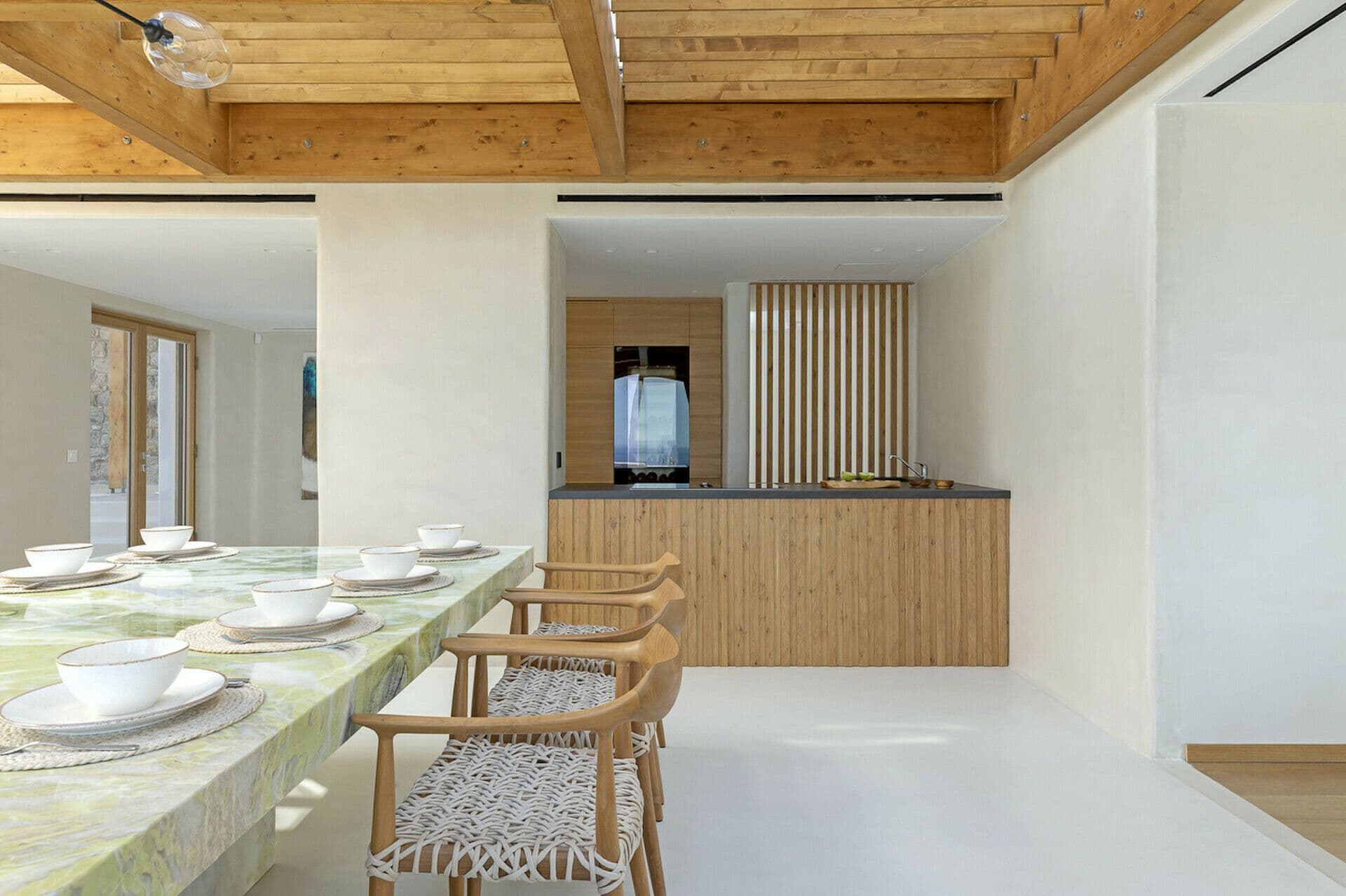 Kitchen with a green-marble breakfast bar and woven stools at Cycladic Wonder, Mykonos