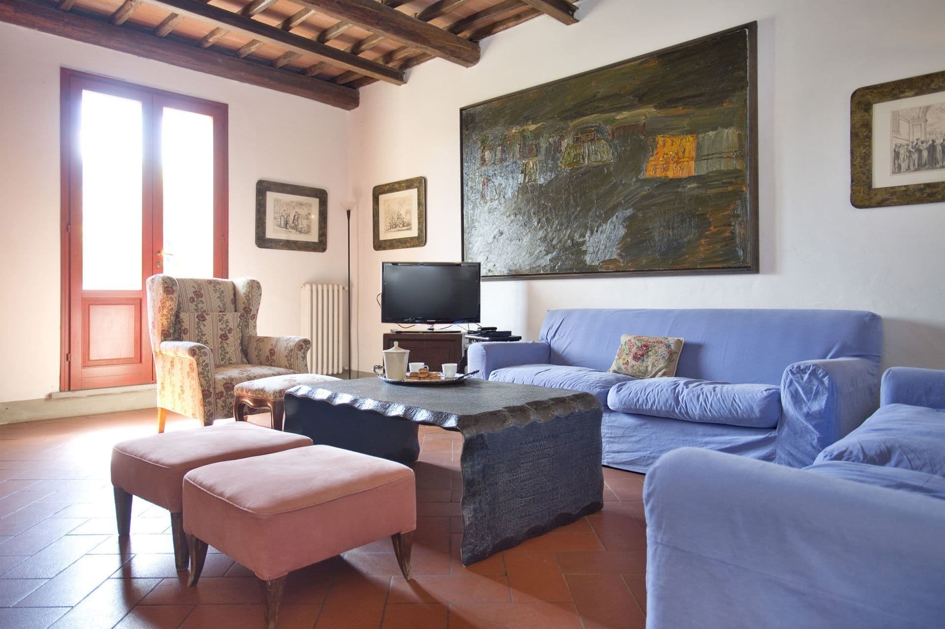 Living room with blue sofas and terracotta floor at Picturesque Hideaway