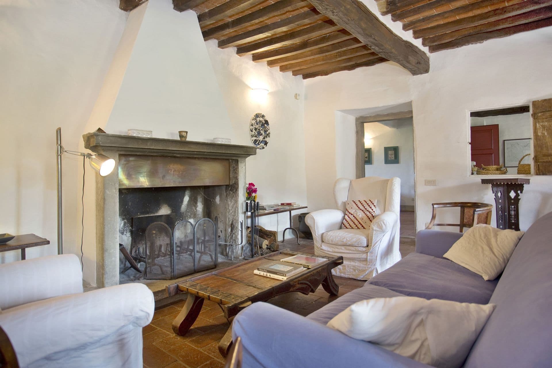 Beamed-ceiling living room with stone fireplace at Picturesque Hideaway