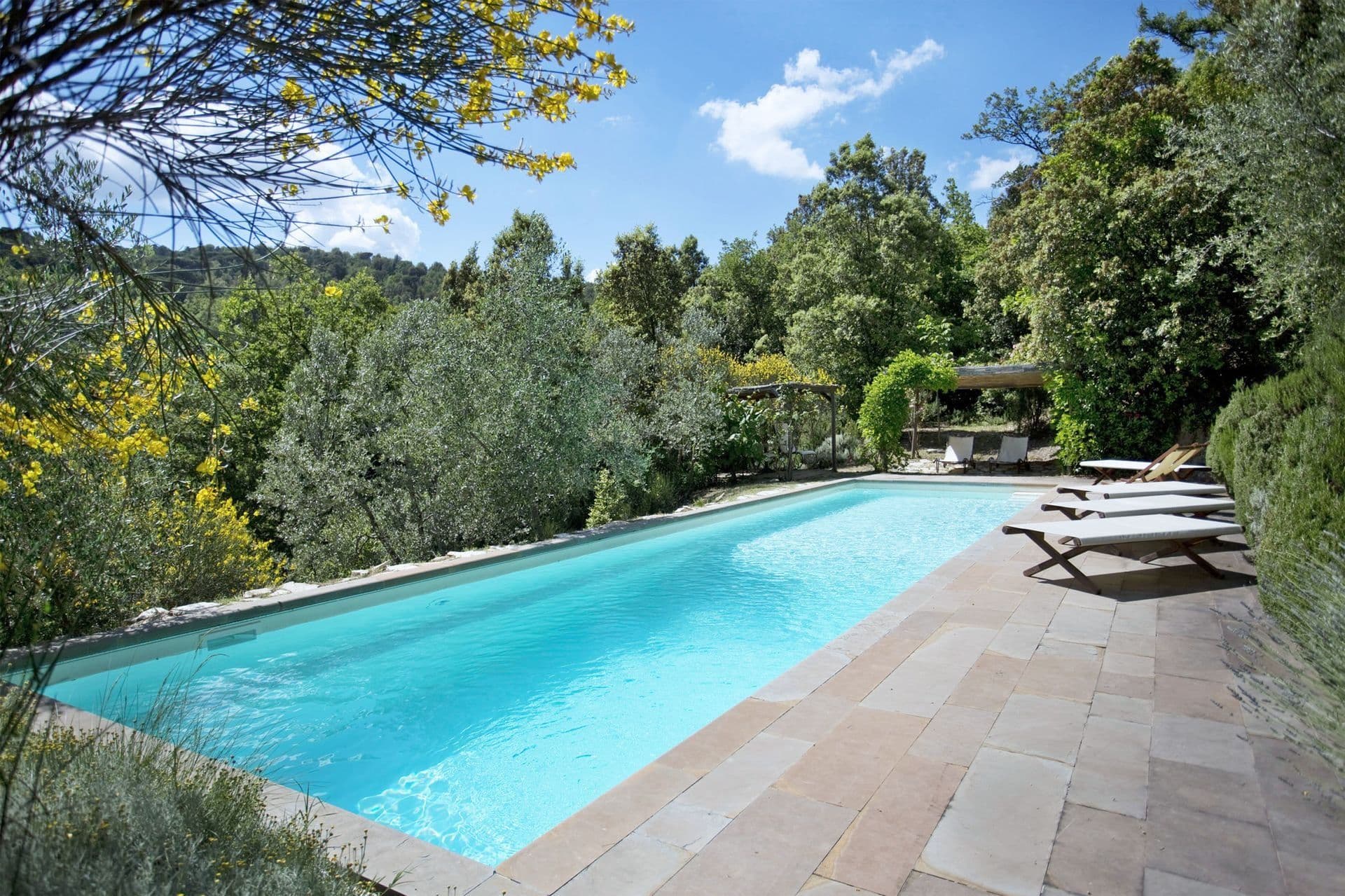 Swimming pool with the stone farmhouse behind at Picturesque Hideaway in Tuscany