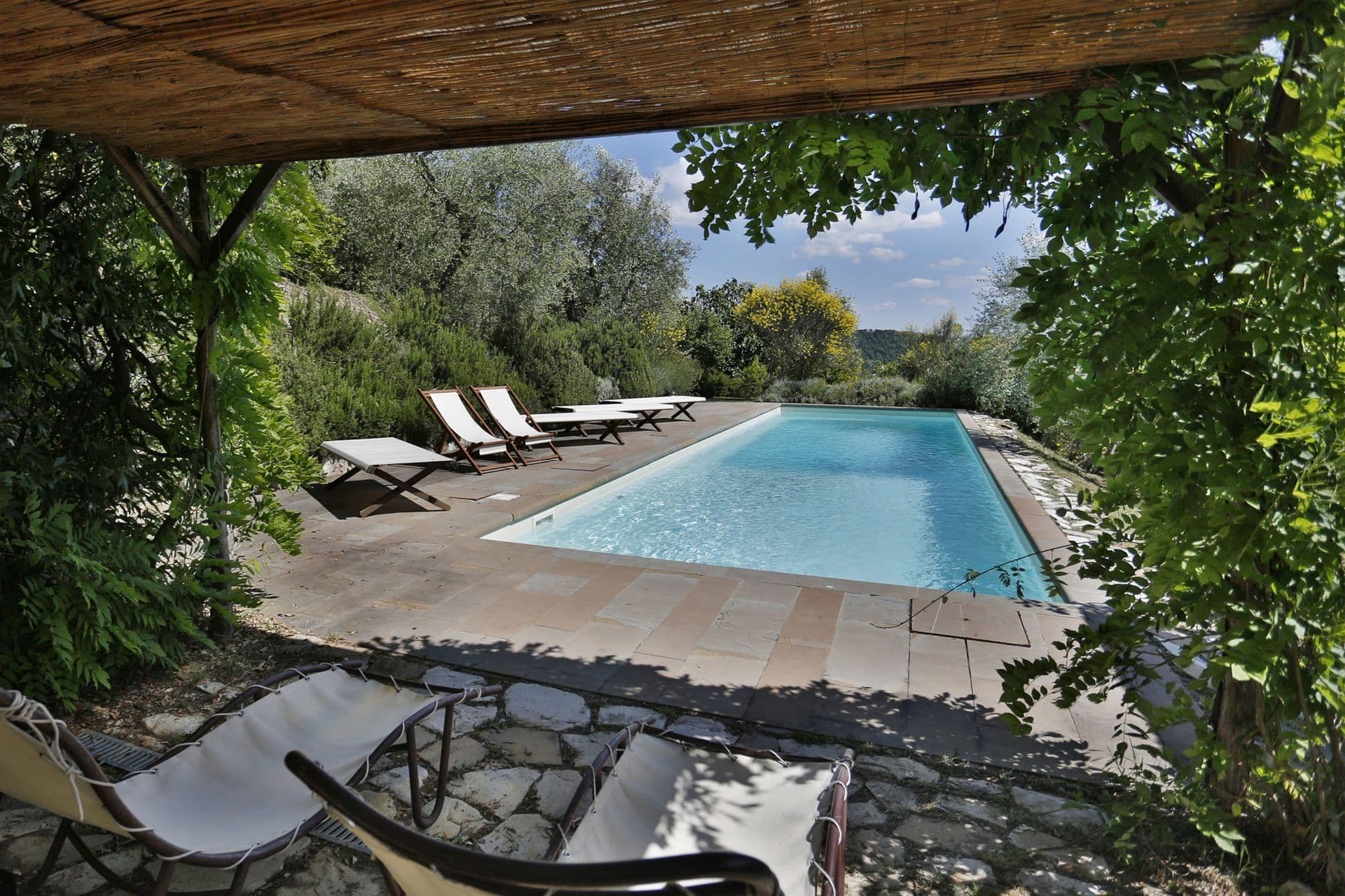 Covered terrace overlooking the pool and countryside at Picturesque Hideaway
