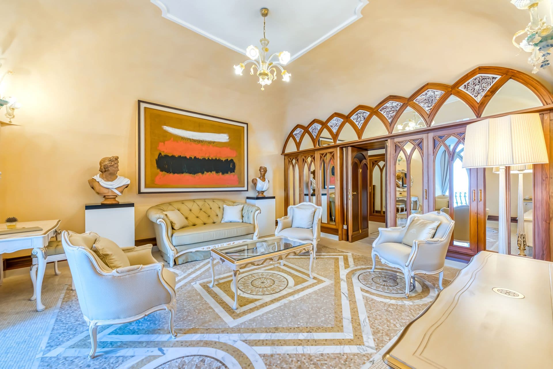 Ornate salon with gilded ceiling, antique furniture and artwork