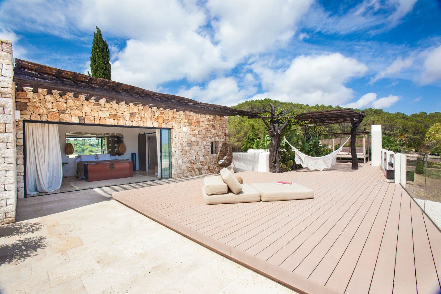 Traditional stone building with wooden deck and hammock
