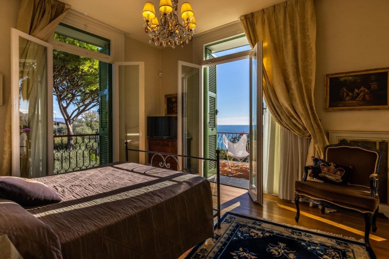 Bedroom with dark wood furniture and sea-view terrace at On the Emerald Coast, Rapallo