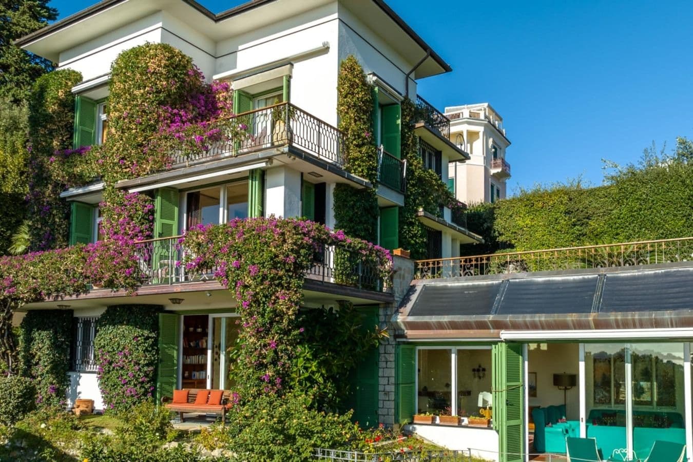 Ivy-clad Ligurian villa facade with green shutters and balconies at On the Emerald Coast, Rapallo