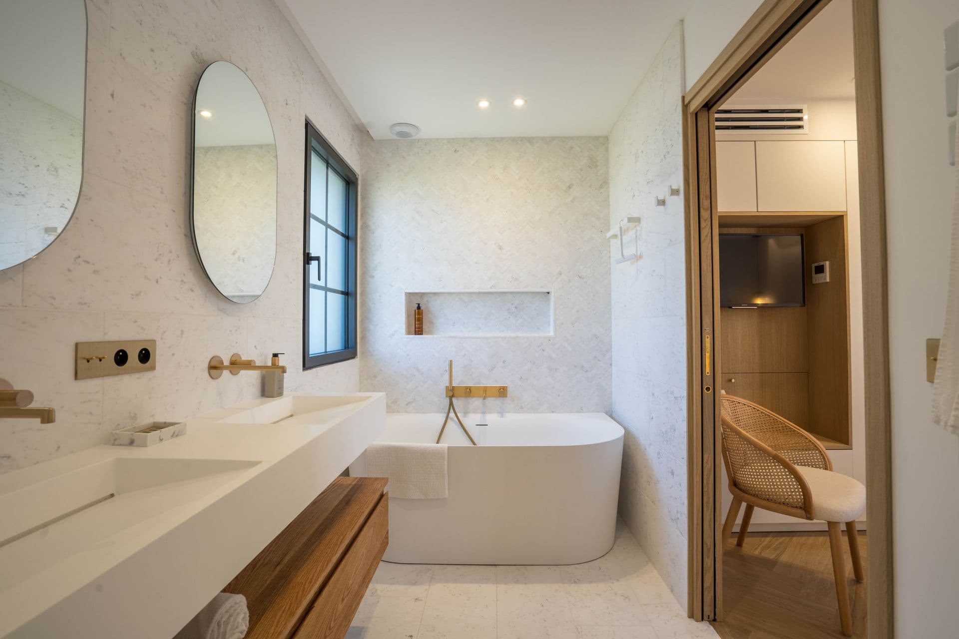 En-suite bathroom with a freestanding tub and marble-topped double vanity