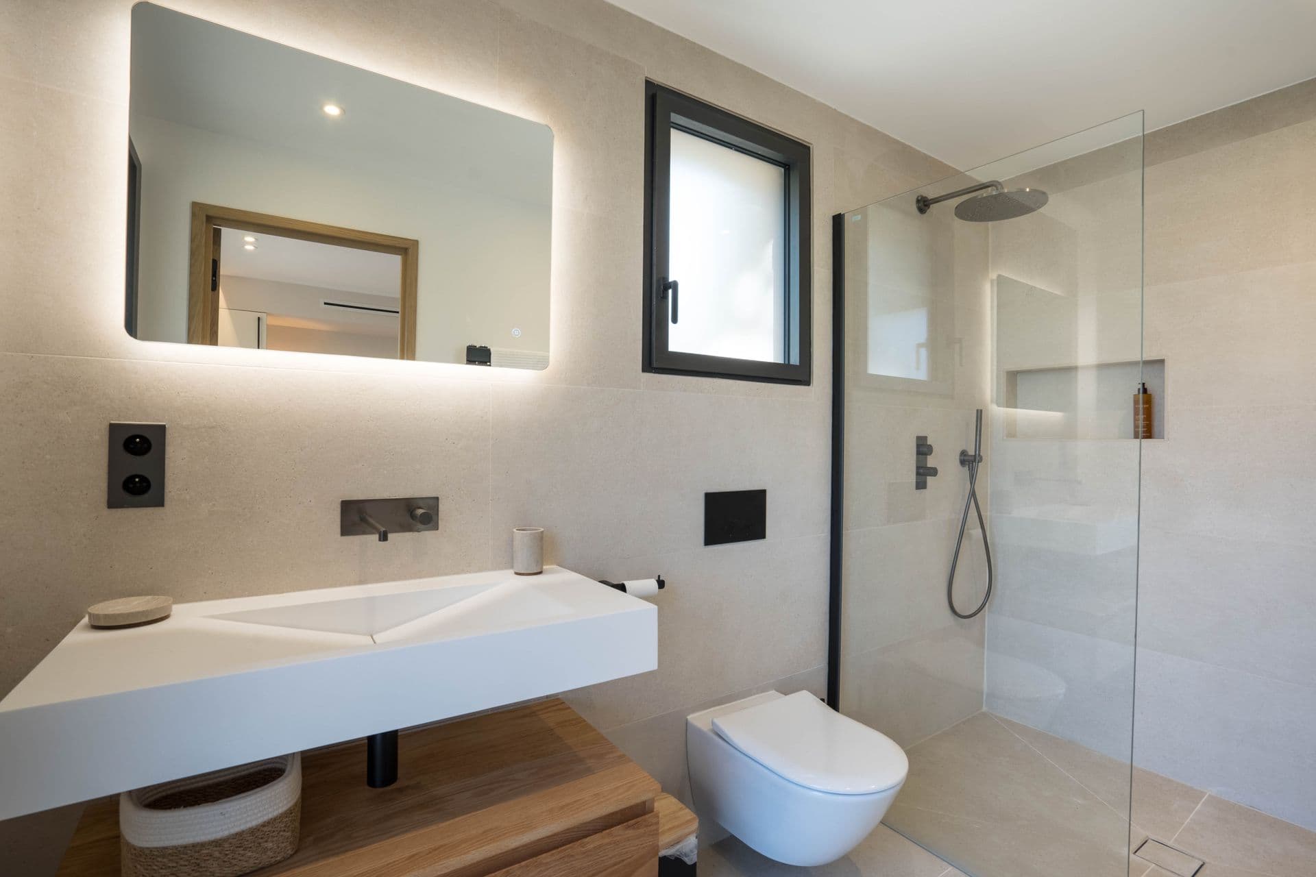 Bathroom with a floating sink counter beside a glass-walled shower