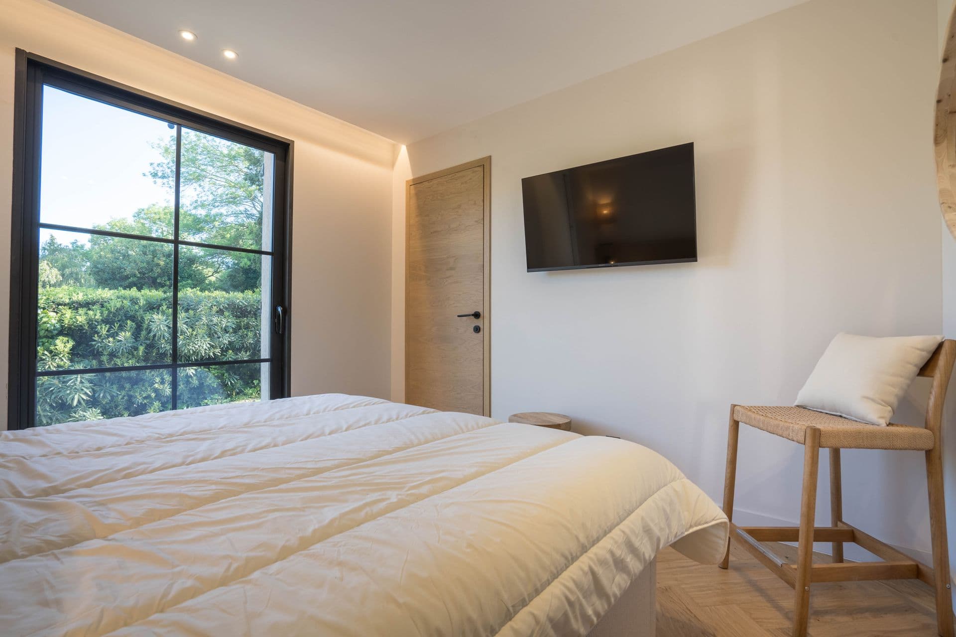 Bedroom with headboard wall lighting and a wall-mounted television