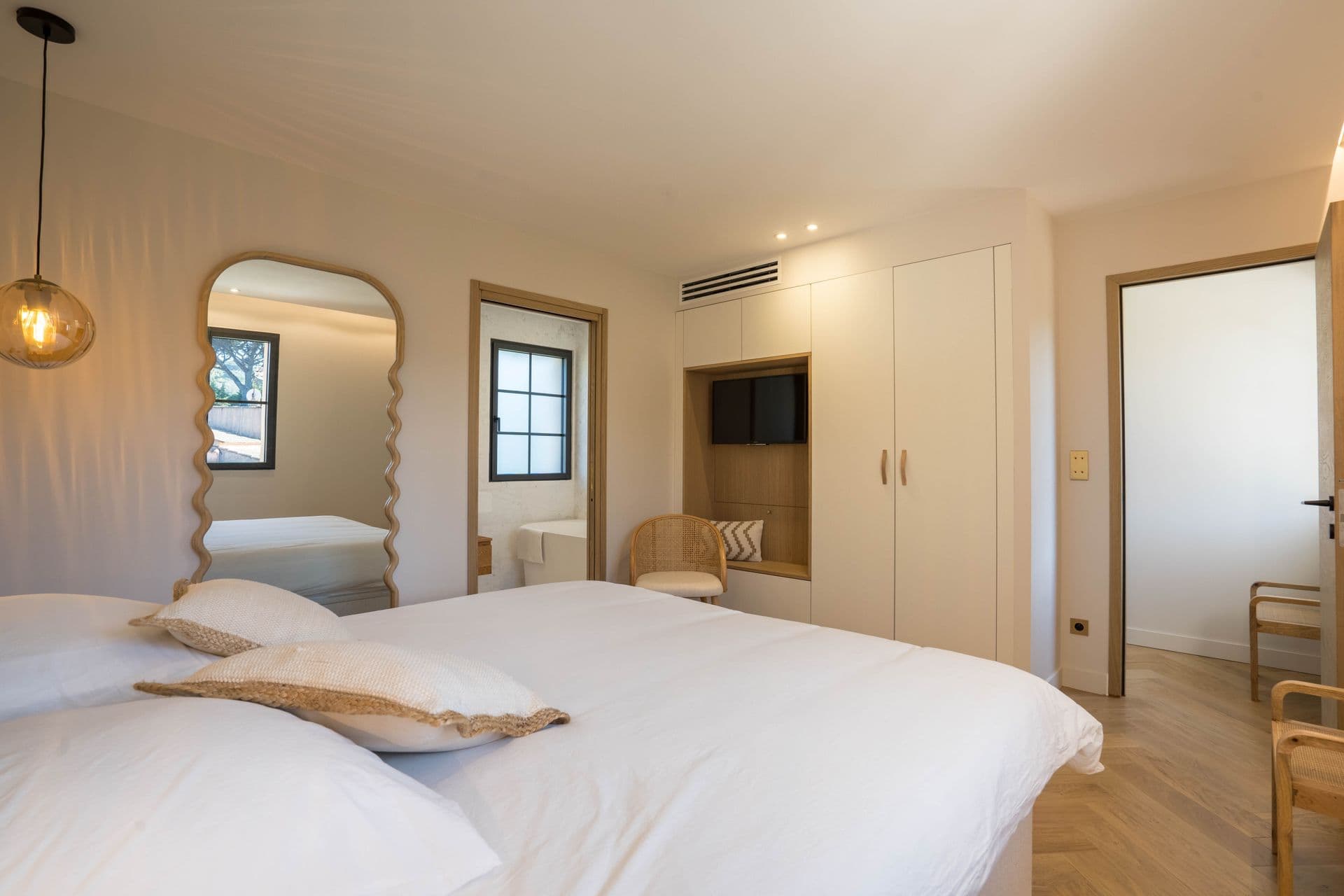 Twin bedroom with matching beds and arched dressing mirror