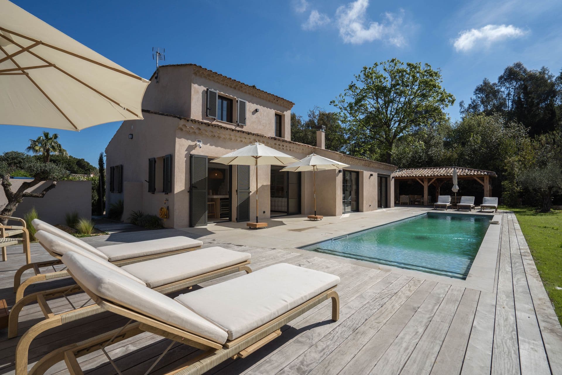Villa terrace and pool with sun loungers at golden hour