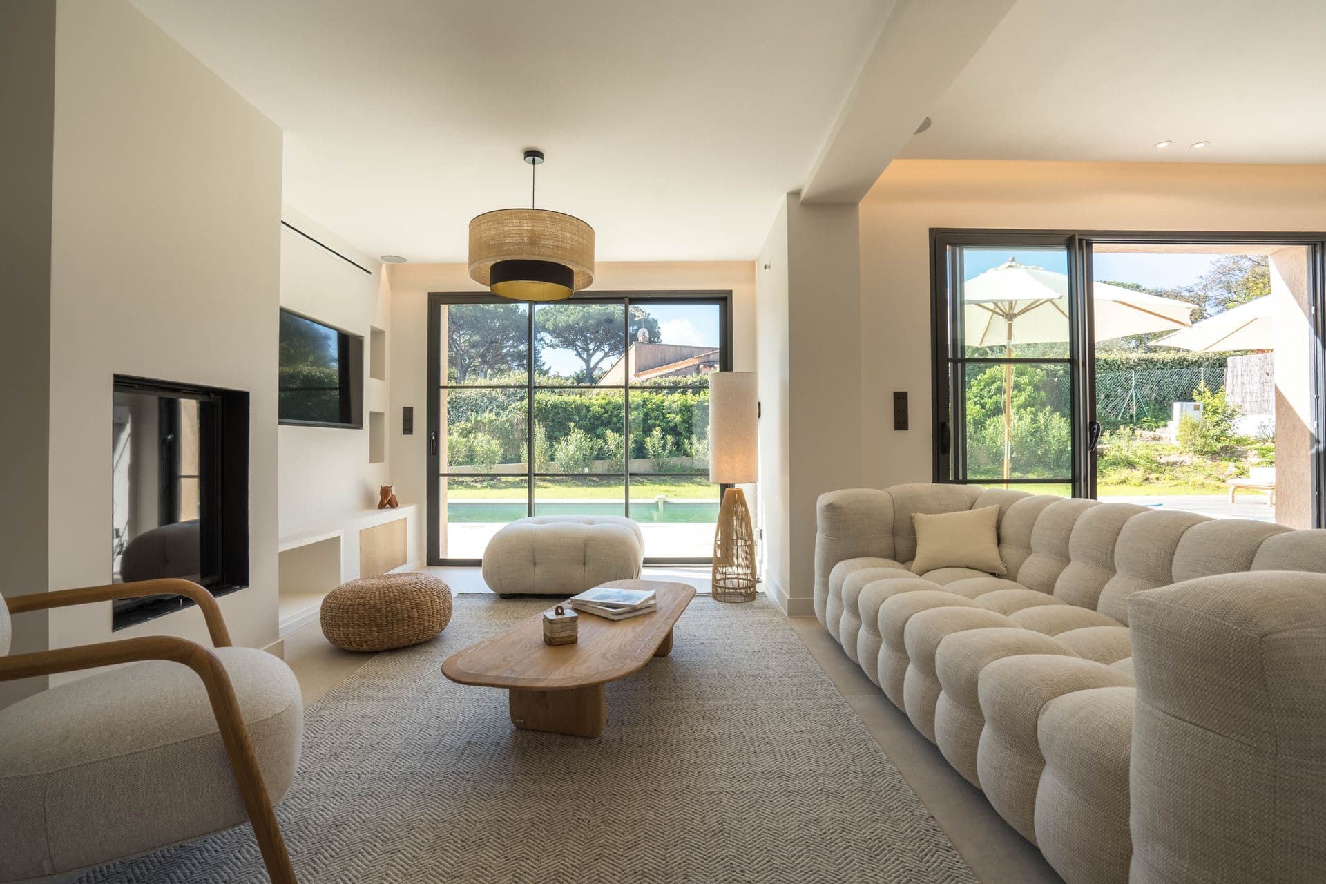Living room with linen sofas, wall-mounted television and garden views