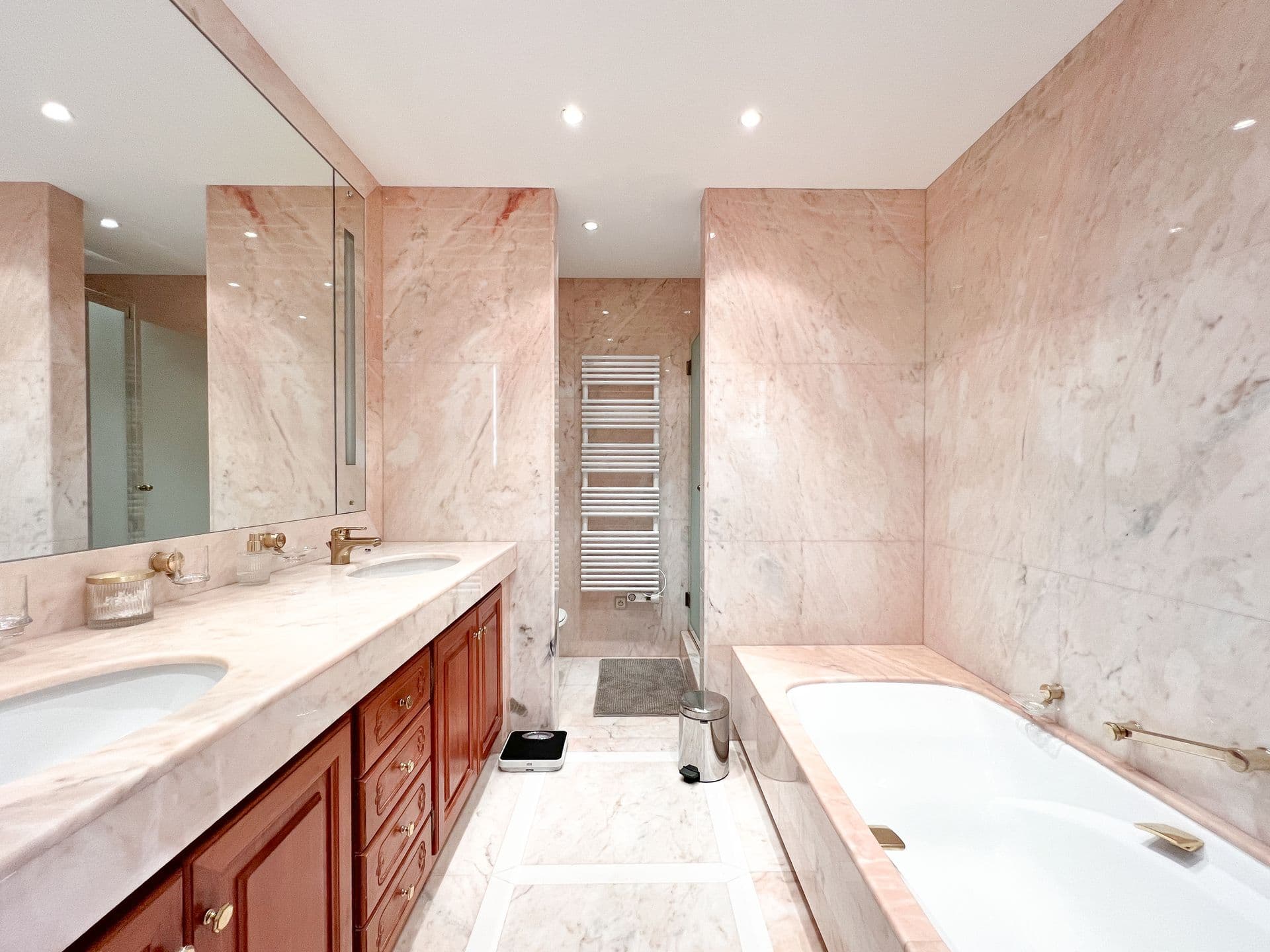 Marble-clad bathroom with double sinks and heated towel rail at Golden Escape