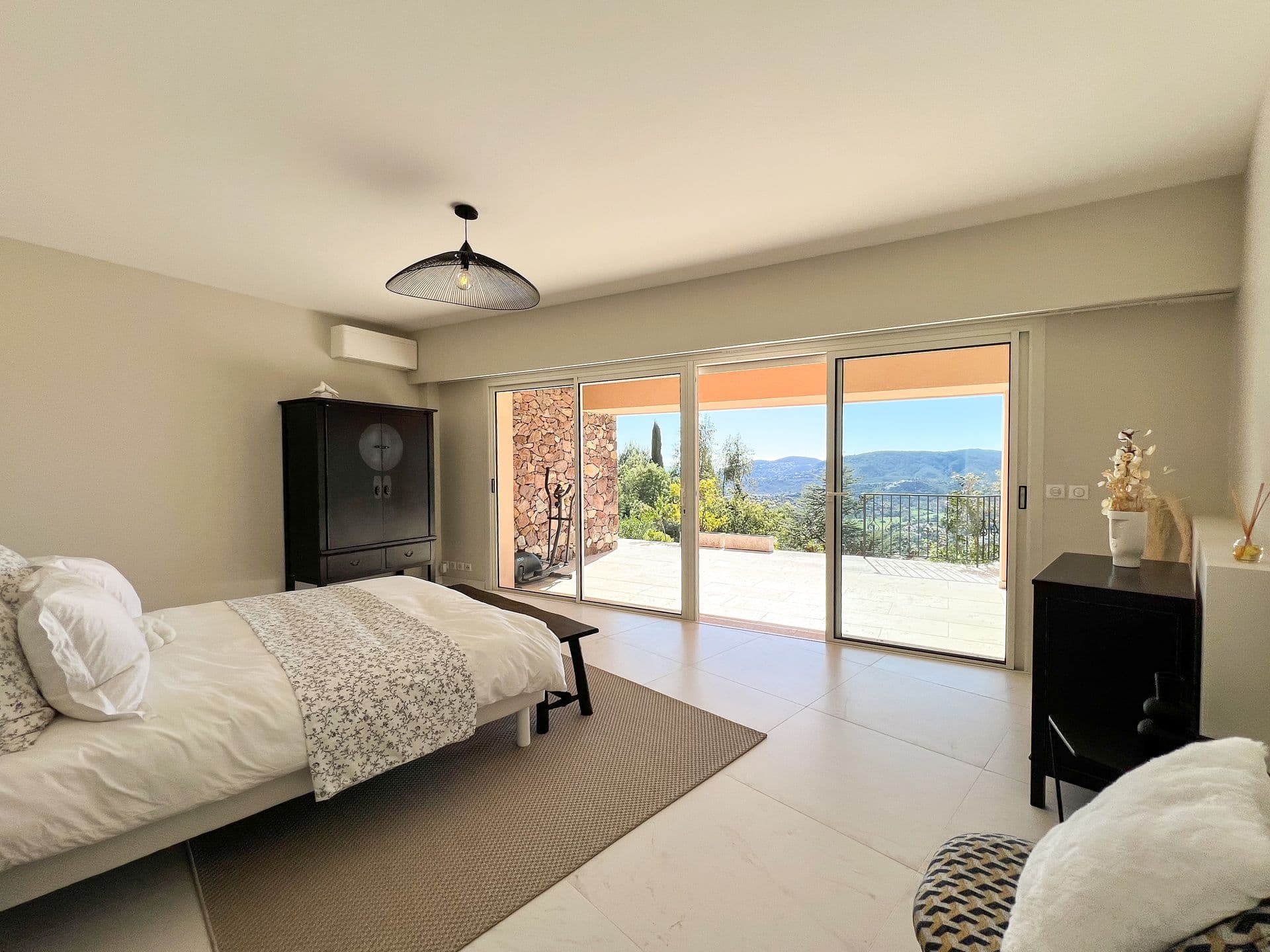 Bedroom in neutral tones with air conditioning and terrace doors at Golden Escape