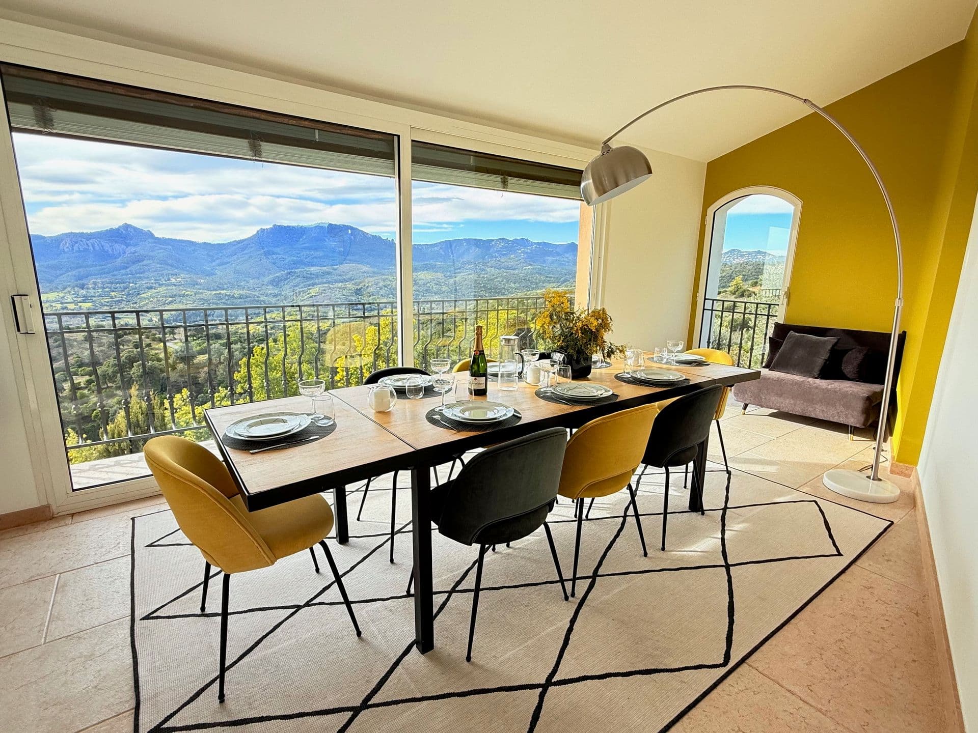Indoor dining table with mustard chairs and mountain views at Golden Escape